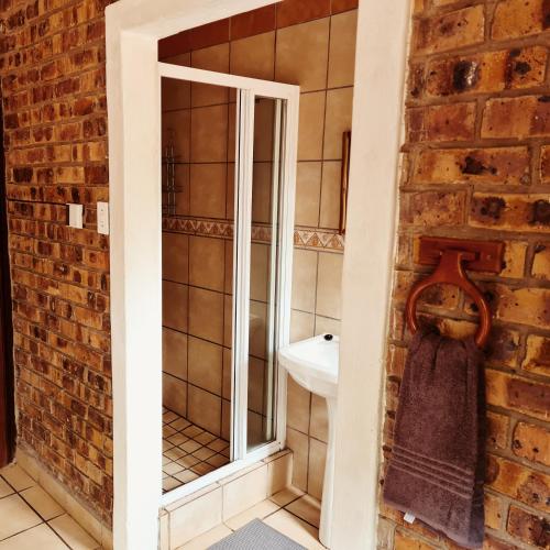 a bathroom with a toilet and a sink in a brick wall at Umvangazi Rest in Marloth Park