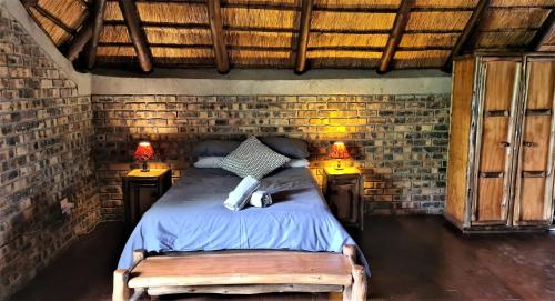 a bedroom with a bed in a brick wall at Umvangazi Rest in Marloth Park