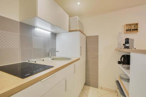 une cuisine blanche avec un évier et un comptoir dans l'établissement Les Cosy De Nancy - La cache du cerf - 4étoiles, à Nancy