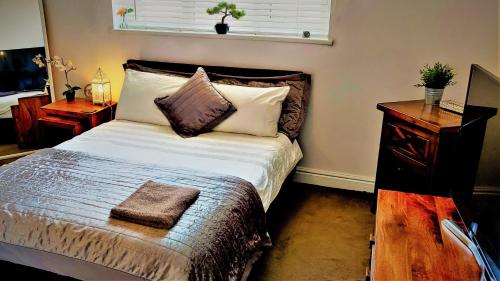 a bedroom with a bed with a pillow and a night stand at Freemantle Solent Lodge SGH in Southampton