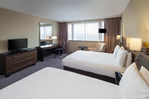 a hotel room with two beds and a television at Crowne Plaza Glasgow by IHG in Glasgow