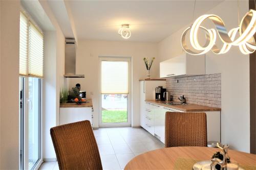 cocina con mesa, sillas y lámpara de araña en family + friends apartment ferienwohnung, en Ransbach-Baumbach