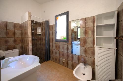 La salle de bains est pourvue d'une baignoire, de toilettes et d'un lavabo. dans l'établissement Residence "U LATONU", à Porto-Vecchio