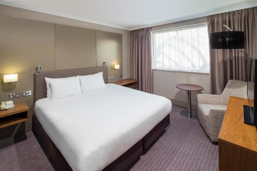 Habitación de hotel con cama grande y sofá en Crowne Plaza Glasgow, an IHG Hotel, en Glasgow