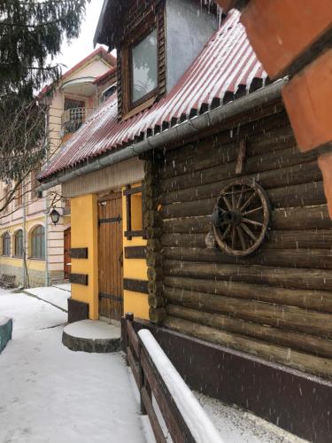 a wooden cabin with a wheel on the side of it at Nautilus in Uzhhorod
