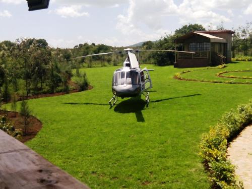 a helicopter flying over a field of grass at Sangare Gardens- Book Now Enjoy Free Farm Tour in Mweiga