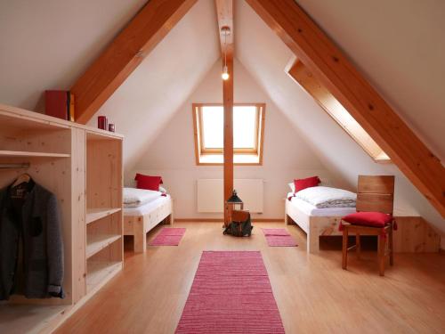 a attic room with two beds and a window at Oskar's Chalets in Hinterzarten