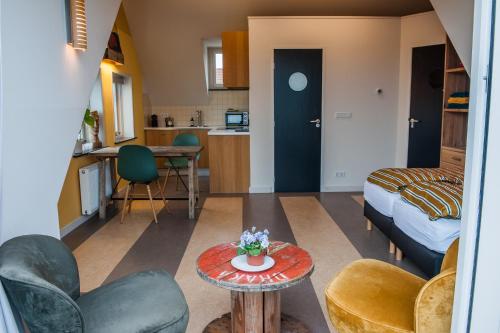 een kleine woonkamer met een bed en een tafel bij Studio aan Zee in Westkapelle