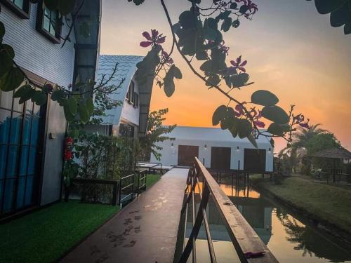 a view of a building with a sunset in the background at ข้าวทุ่งเบ็ญจาโฮมสเตย์ in Ban Hat Phang