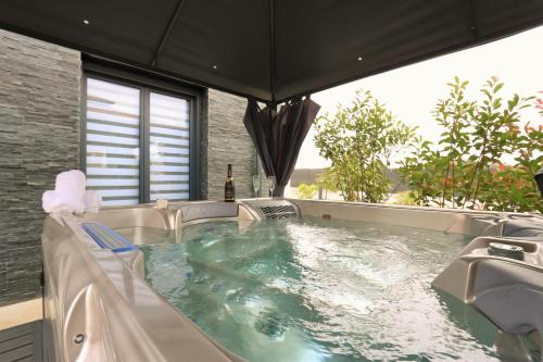 a jacuzzi tub in a room with a window at TOPAZE Nuitée Romantique avec Jacuzzi in Moyvillers