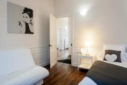 - une chambre blanche avec 2 lits et une porte dans l'établissement Au fil de Troyes, à Sainte-Savine