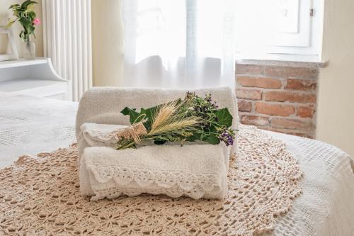 ein Schlafzimmer mit einem Stuhl mit Blumenarrangement darauf in der Unterkunft Villa Curte Nicia in Nizza Monferrato