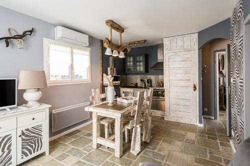 cocina con mesa con sillas y ventana en Hôtel particulier- Les cottages du Bassin d'Arcachon -Petit-déjeuner sur demande, en Gujan-Mestras