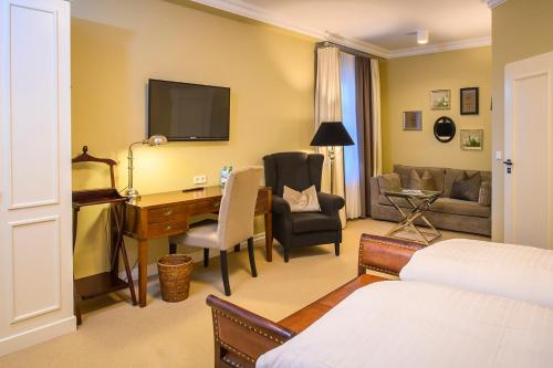 a hotel room with a desk and a bedroom at Landhotel Donner in Meschede