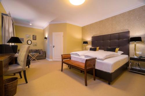 a bedroom with a bed and a desk and a couch at Landhotel Donner in Meschede