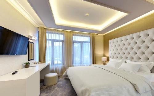 a bedroom with a large bed and a large window at Tsarevets Boutique Hotel & SPA in Veliko Tŭrnovo