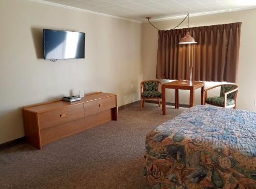 a hotel room with a bed and a desk and a table at Aquarius Inn in Bicknell