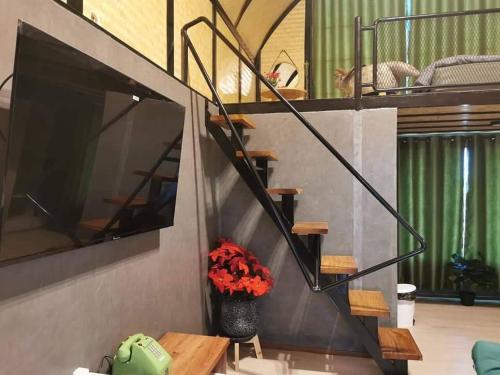 a staircase in a living room with a vase of flowers at ข้าวทุ่งเบ็ญจาโฮมสเตย์ in Ban Hat Phang