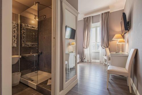 Un baño con ducha, lavabo y espejo. en Domus Castrense, en Roma