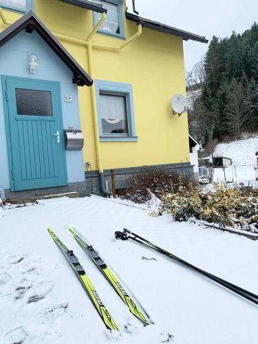 two skis in the snow in front of a house at Ferienhaus im Kumbachtal in Gräfenthal