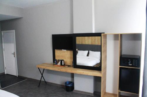 a room with a tv and a shelf at Skylon Airport Hotel in Arnavutköy