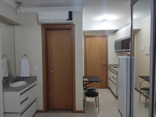 a kitchen with a sink and a wooden door at Apart Hotel Saint Moritz - Centro de Brasília in Brasilia
