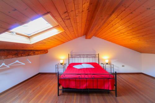 a bedroom with a red bed in a attic at Da Anna in Cremia