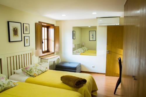 a hotel room with two beds and a mirror at Casa de Romao in Amares