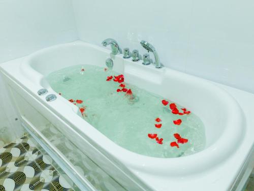 un fregadero blanco con corazones rojos. en NHÀ NGHỈ K house, en Ben Tre