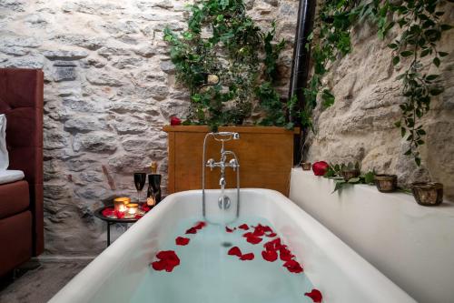 a bath tub filled with red roses in a bathroom at Rataskaevu Boutique - 7 Unique Apartments in Tallinn