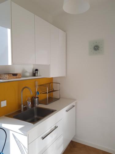 a kitchen with white cabinets and a sink at Blick über Krems mit Terrasse in Krems an der Donau