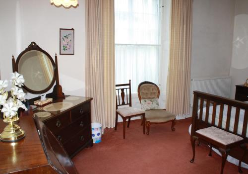 a room with a dresser and chairs and a mirror at Guillemots in North Berwick