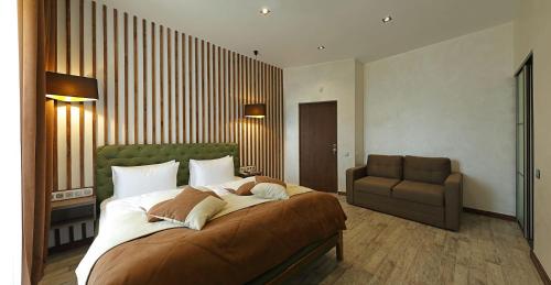 a bedroom with a large bed and a couch at Mountain Residence Apartments & Chalet in Bukovel
