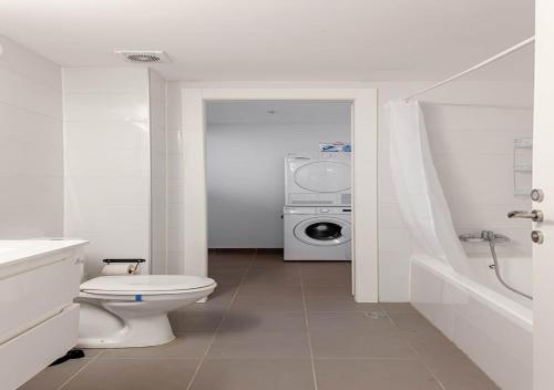 a bathroom with a toilet and a washing machine at Oַ&O Group- Luxury 3BR APT 33 Floor Sea View Tower in Bat Yam