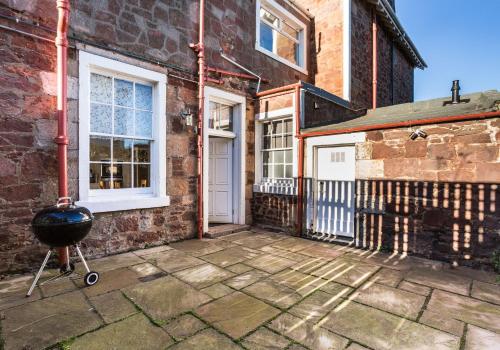 a brick house with a grill in front of it at Firth View in North Berwick