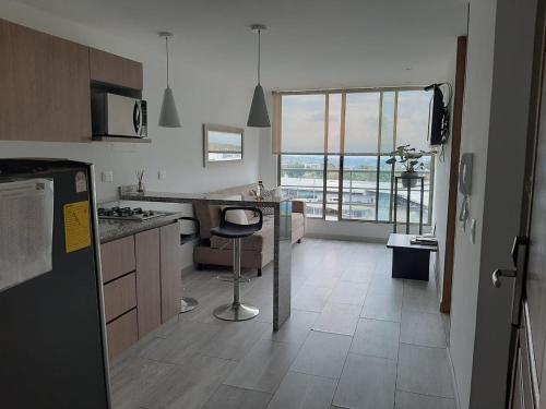 Santorini Apartamentos Amoblados في بيريرا: مطبخ مع كونتر وكرسي فيه