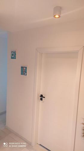 a white door with two signs on the wall at Apartament Karlikowska z widokiem na morze in Sopot