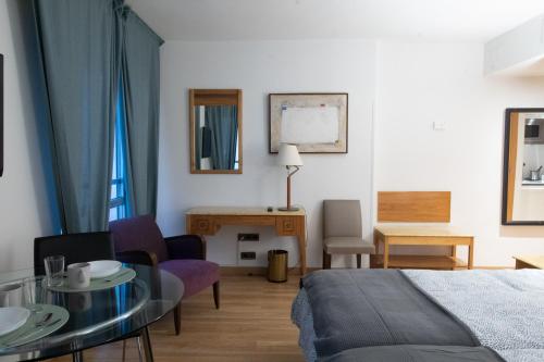 um quarto com uma cama, uma mesa e cadeiras em Estudio para dos en pleno centro de Madrid em Madri