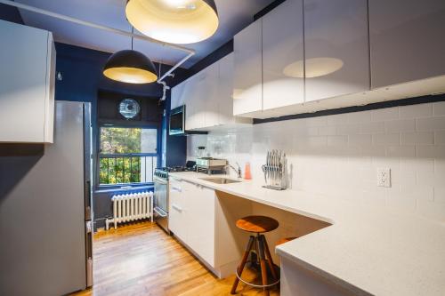 a kitchen with white cabinets and a counter top at Lamartine Chelsea in New York