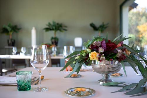 a table with a vase of flowers and a wine glass at Villa Necchi alla Portalupa in Gambolò