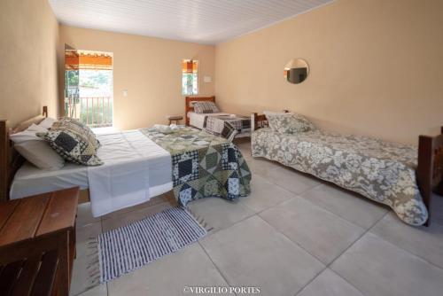a living room with a bed and a couch at Pousada Recanto da Lu in Paraty