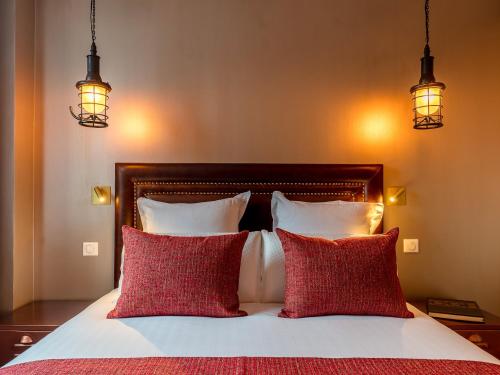 a bedroom with a bed with two red pillows at BE YOU LUXURY APART'HÔTEL-LA GENTLE in Paris