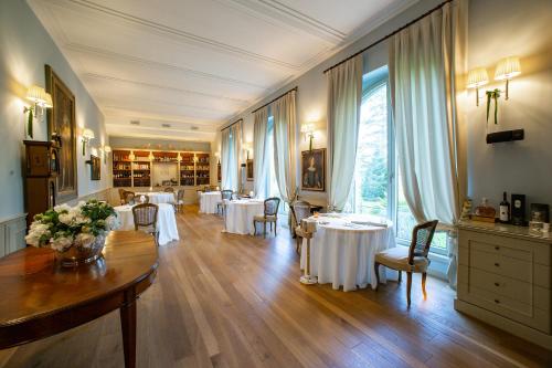 a restaurant with white tables and chairs in a room at Villa Necchi alla Portalupa in Gambolò