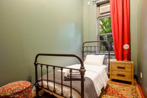 a bedroom with a bed and a window with red curtains at Lamartine Chelsea in New York