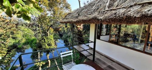 a view from the balcony of a house with a thatch roof at Noah's Nest Tree House in Thekkady