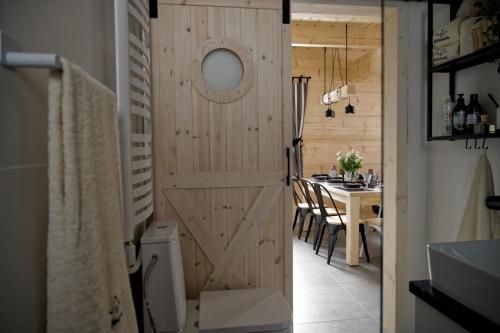 a bathroom with a sliding barn door and a table at Domki Widokówka in Kluszkowce