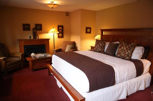 Settlers Inn في Hawley: غرفة فندقية بسرير كبير وموقد