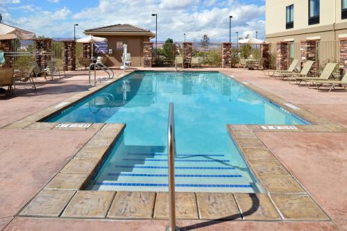a swimming pool at a hotel with chairs around it at Holiday Inn Express & Suites Page - Lake Powell Area by IHG in Page