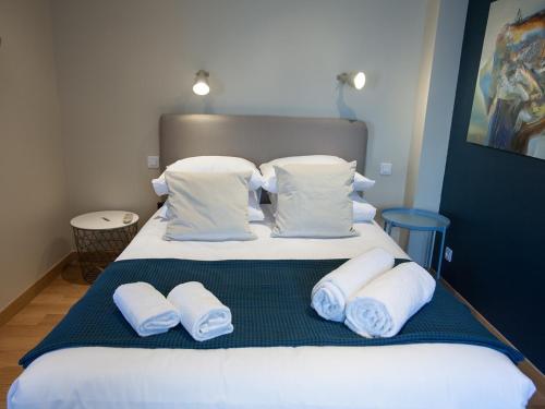 a bed with white pillows and towels on it at Be You Luxury Apart'Hôtel 16 in Paris