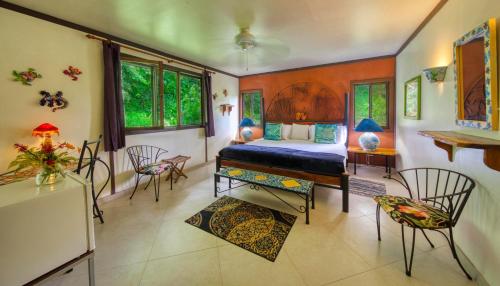 a bedroom with a bed and a table and chairs at Lucky Bug Bed And Breakfast in Nuevo Arenal